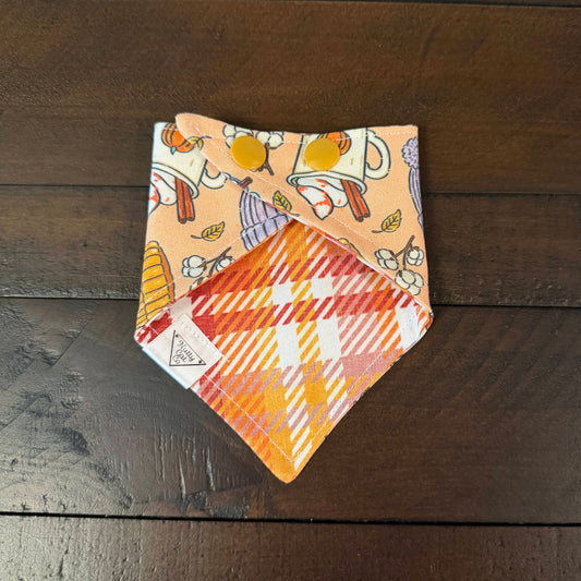 Peach pet bandana with autumn books, mugs, knit hats, cinnamon rolls, hot chocolate and pinecones.