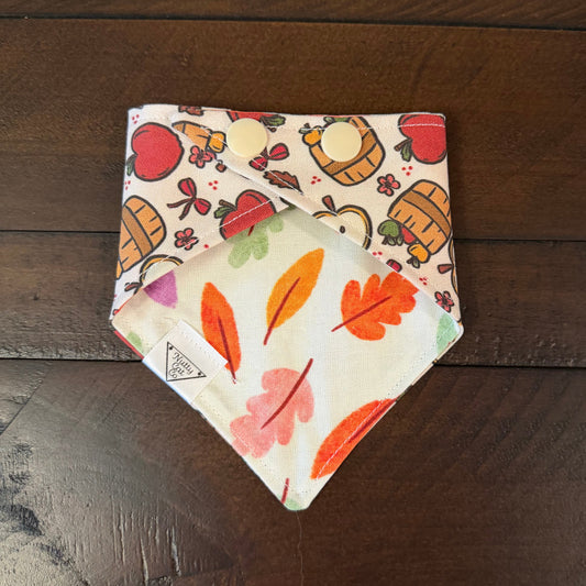 Cream pet bandana with red apples, apple slices, fruit baskets, bows, and small flowers.