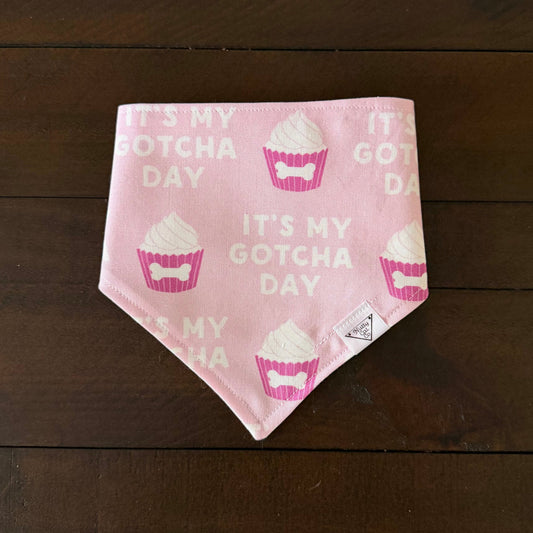 Pink pet bandana with cupcakes decorated with bones and the words It’s my gotcha day.