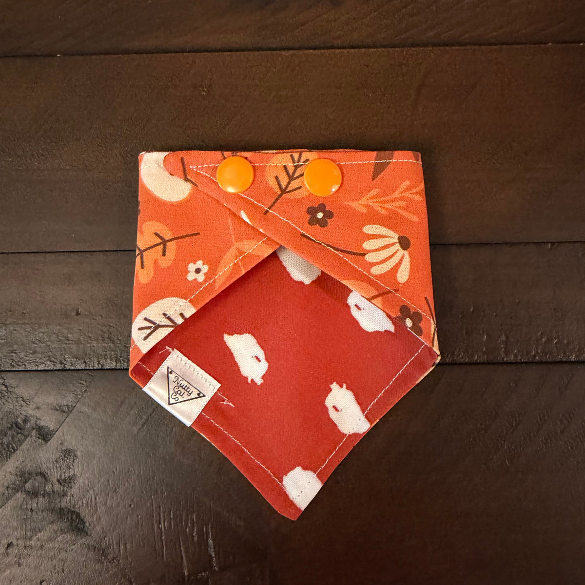 Autumn Accents pet bandana showing an orange reverse with white polka dots and orange snaps.