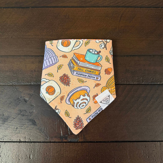 Peach pet bandana with autumn books, mugs, knit hats, cinnamon rolls, hot chocolate and pinecones.