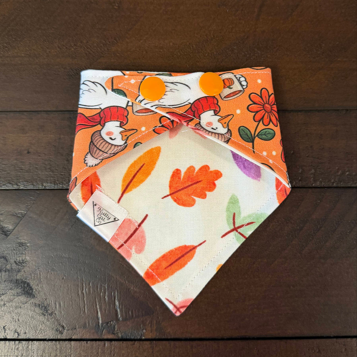 Cozy Goose pet bandana showing a colorful autumn leaf reverse and orange snaps.