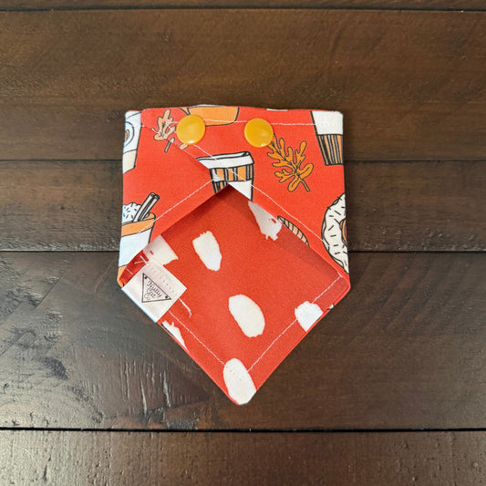 Orange pet bandana with frosted donuts, pumpkin coffee cups, and autumn leaves.