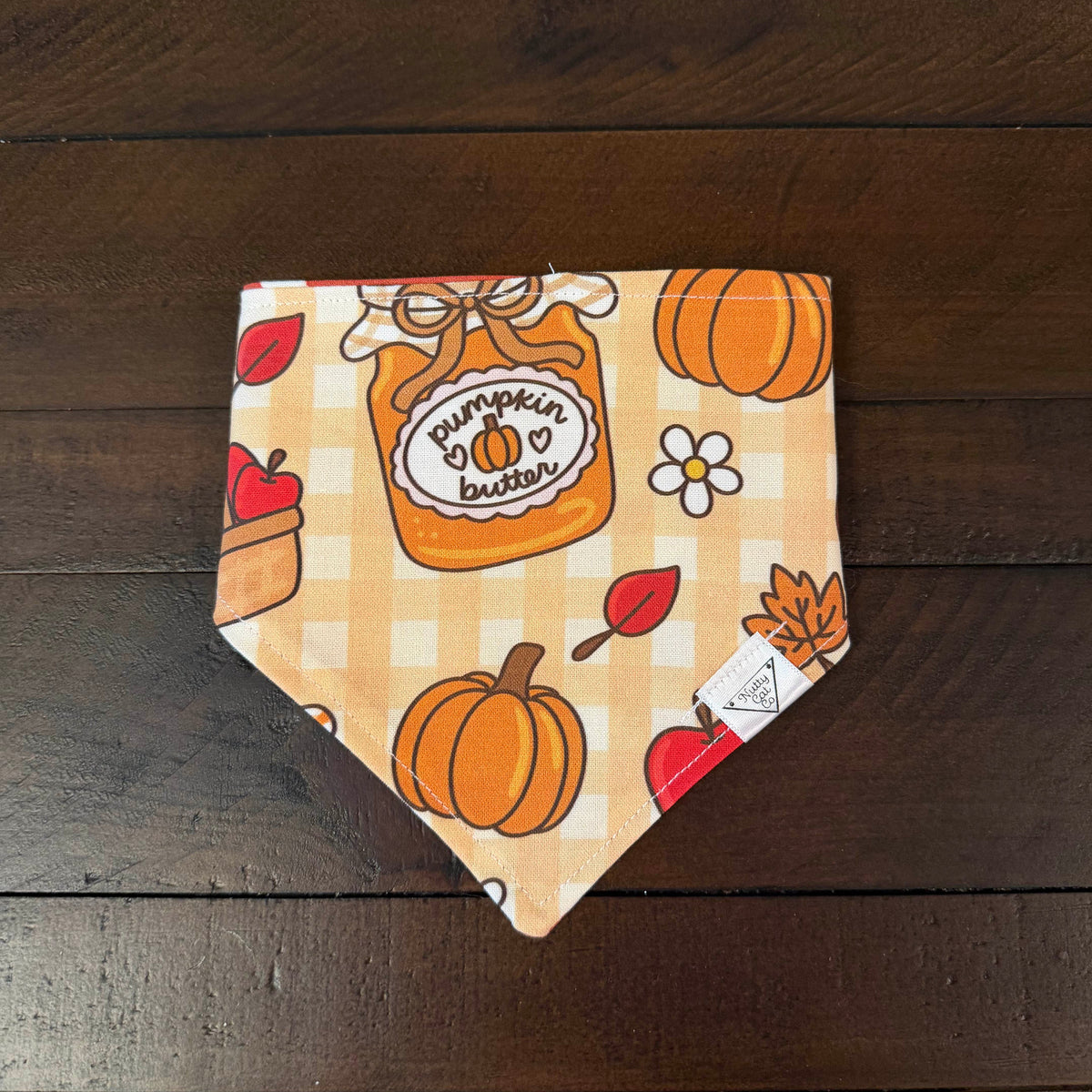 Tan and cream gingham pet bandana with pumpkins, apples, flowers, and a pumpkin butter jar.