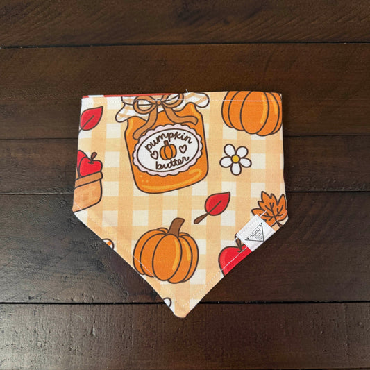 Tan and cream gingham pet bandana with pumpkins, apples, flowers, and a pumpkin butter jar.