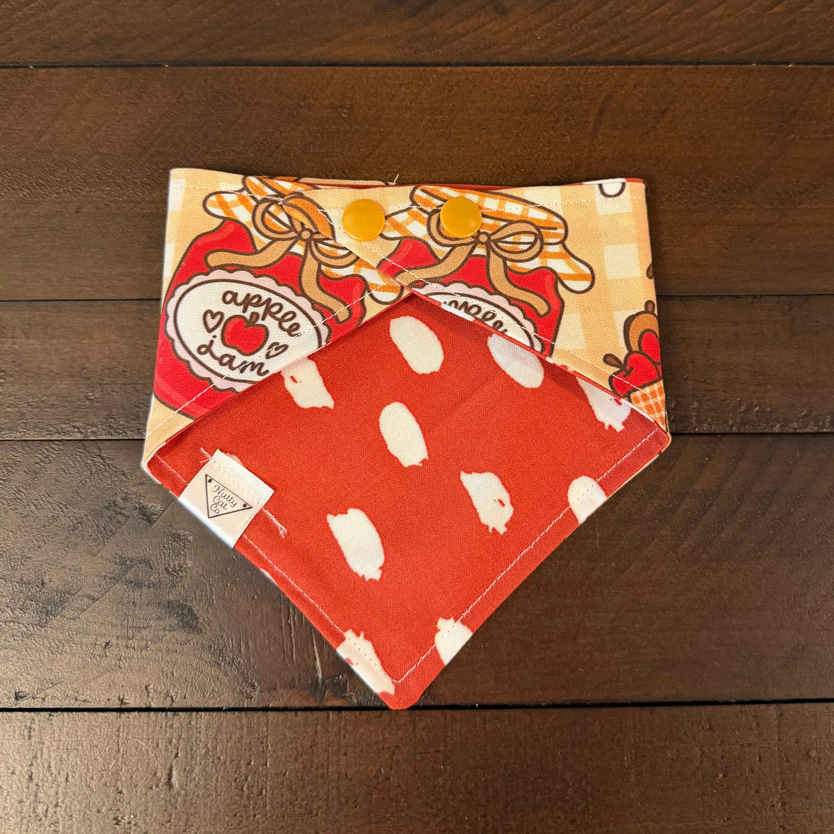 Pumpkin and Apple Butter pet bandana showing an orange reverse with white polka dots and tan snaps.