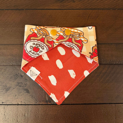 Pumpkin and Apple Butter pet bandana showing an orange reverse with white polka dots and tan snaps.