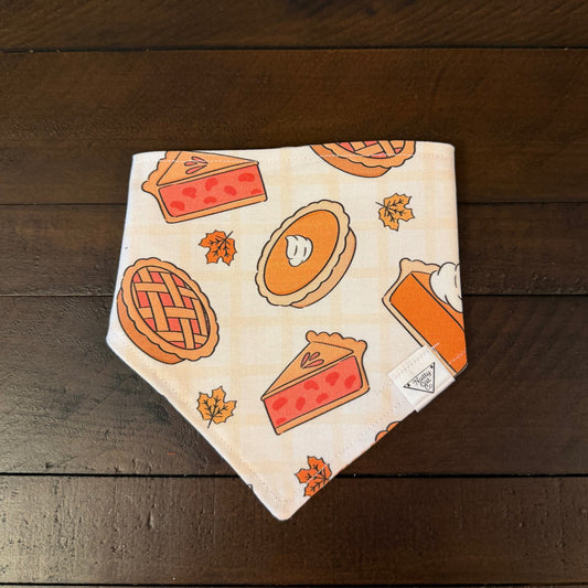 Cream pet bandana with whole pies, pie slices, and orange maple leaves.